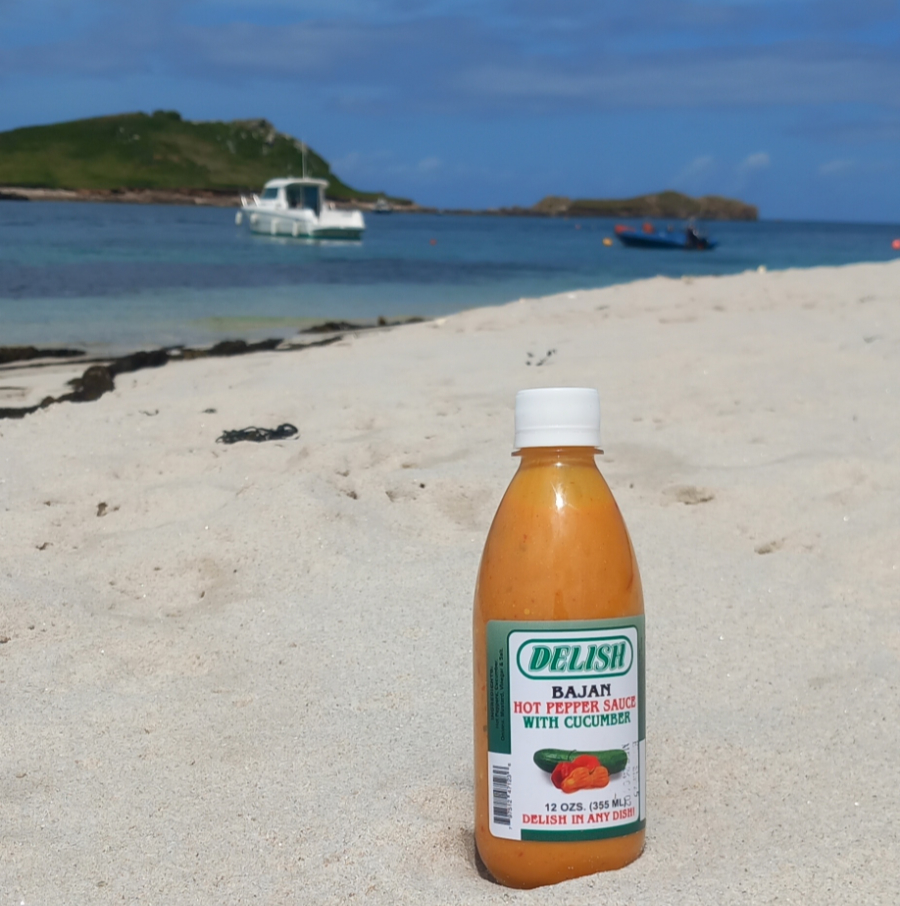 Hot pepper Sauce With Cucumber bottle on a beach